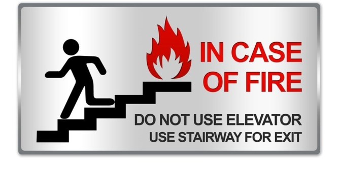 Signage for a stairway that shows a person running down the stairs with the words In Case of Fire Do Not Use Elevator Use Stairway for Exit